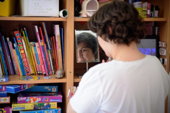 Une jeune fille regarde son reflet dans un miroir